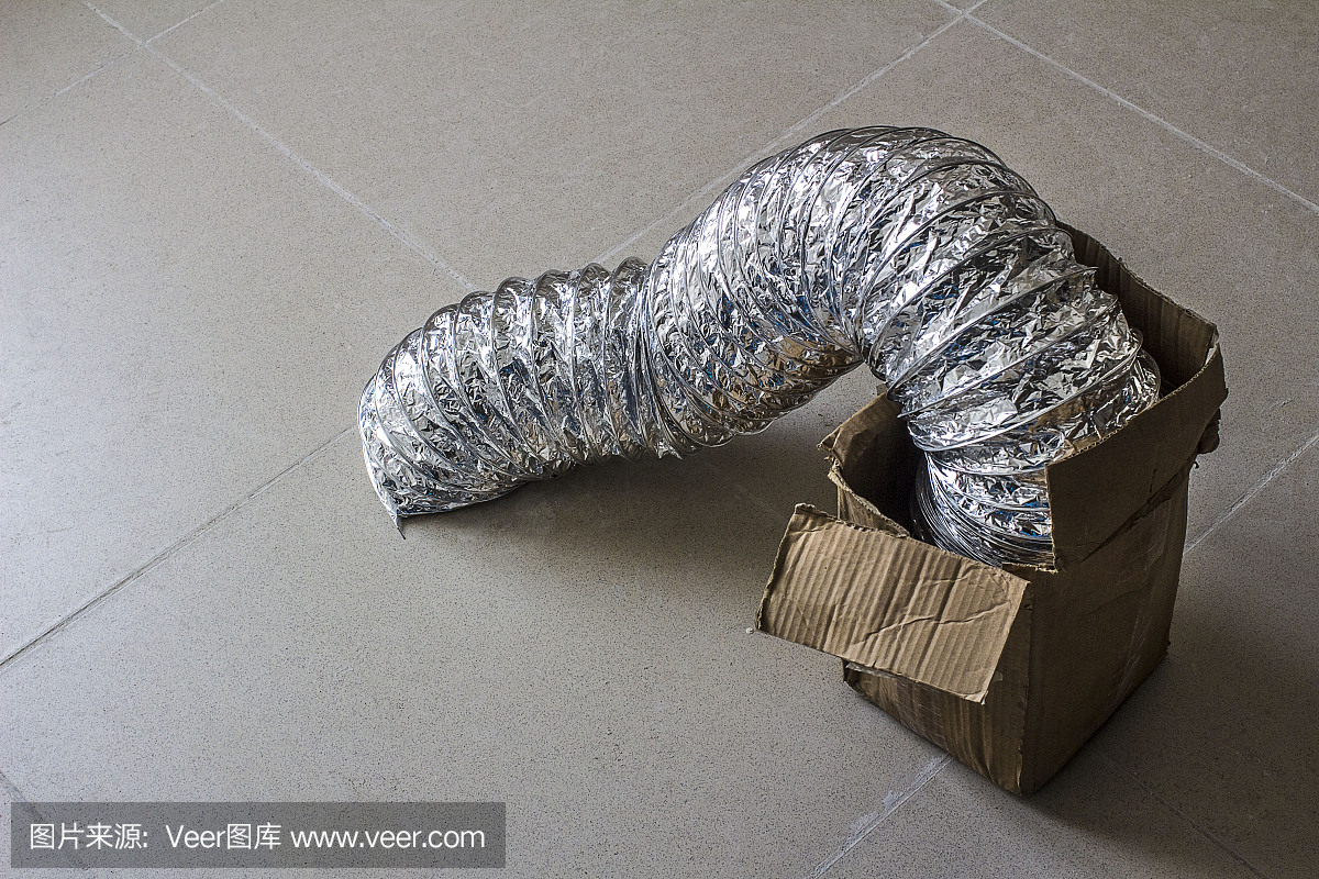 在肮脏的大理石地板上,一个柔软的风管从一个硬纸包里露出来